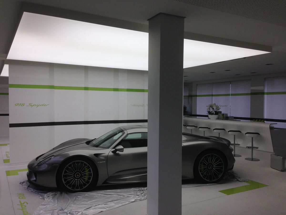 Lichtdecke in einem Autohaus mit Sportwagen darunter