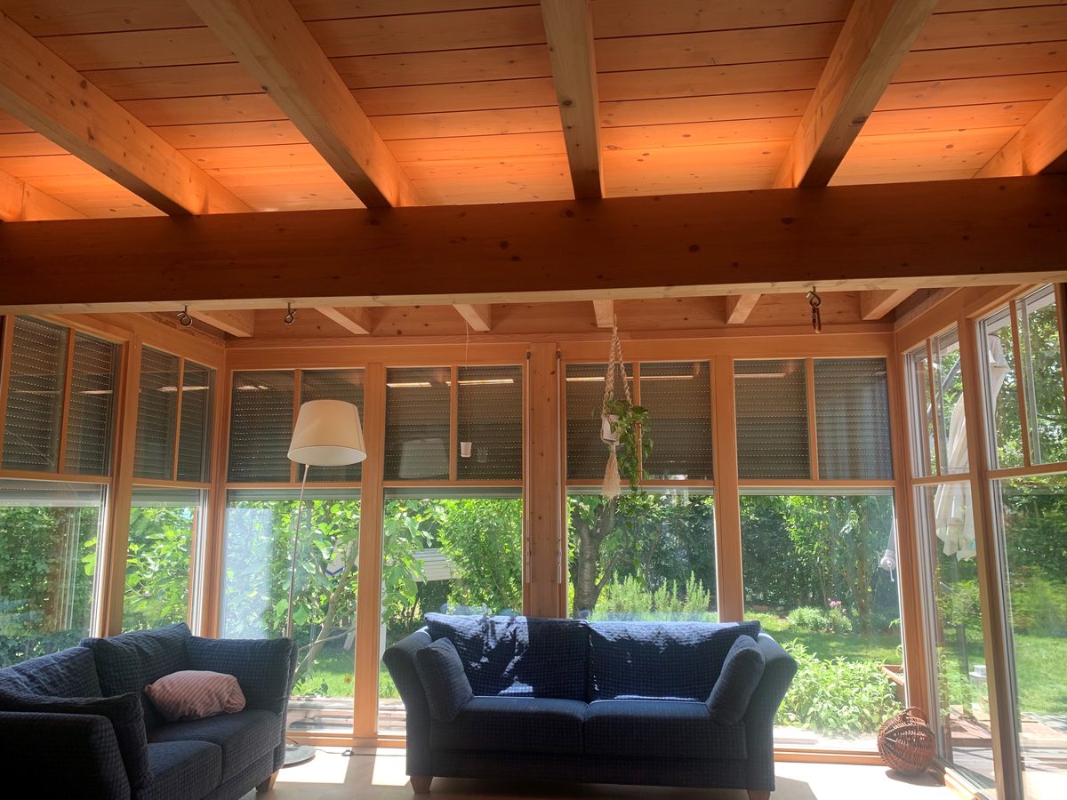 Wohnraum mit indirekt beleuchteten Holzbalken