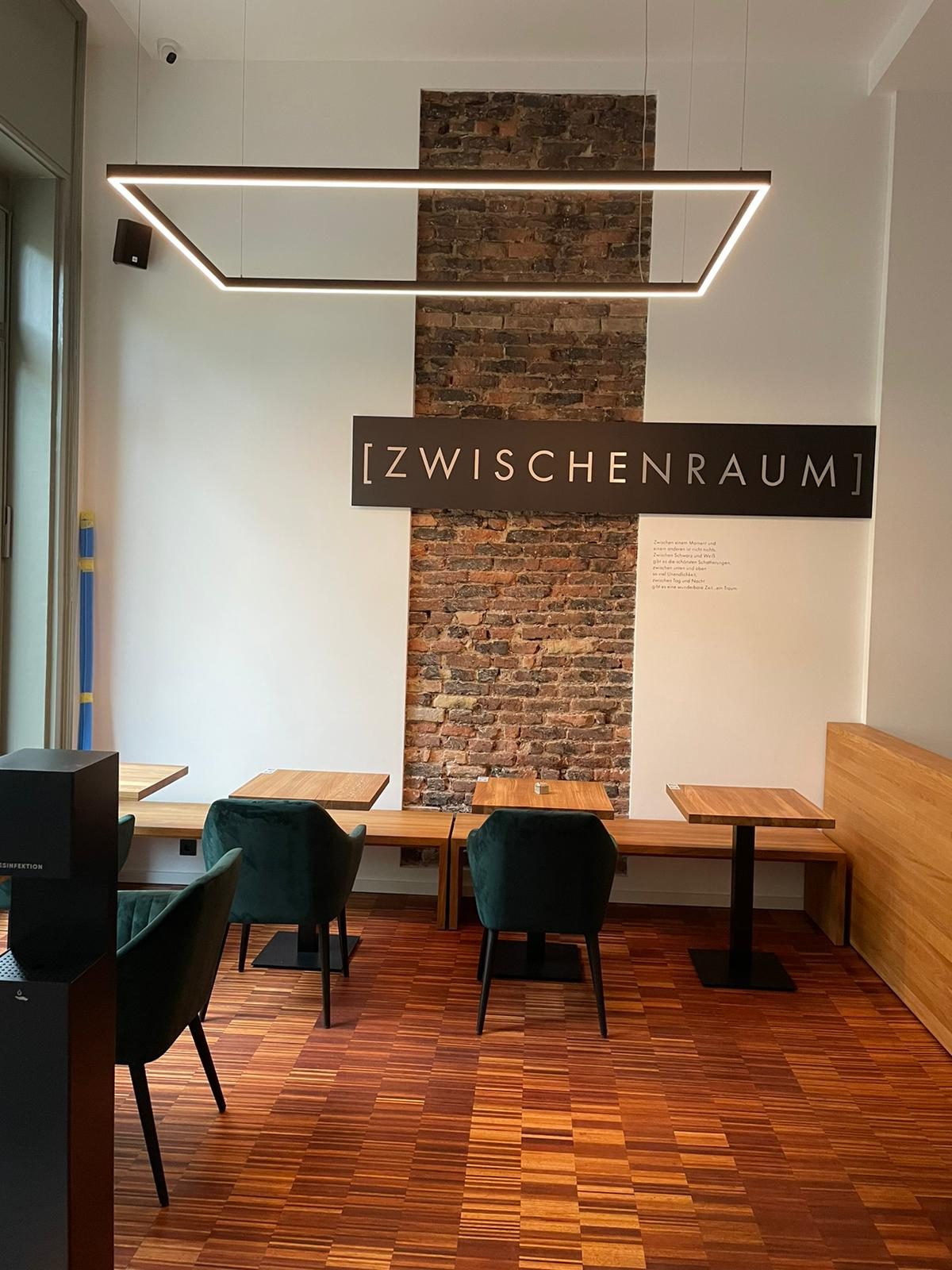 Café mit Lichtrahmen vor einer Backsteinwand