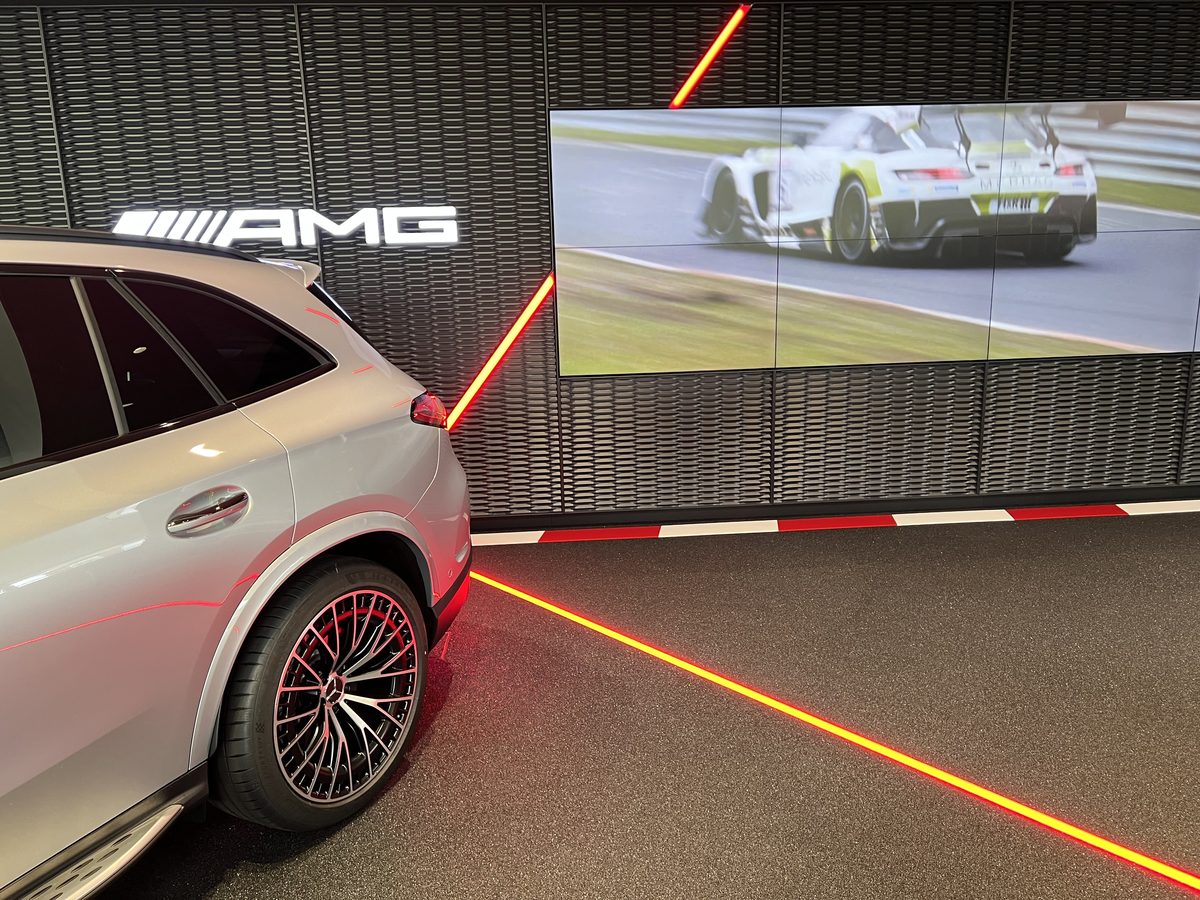 AMG Showroom mit roter Lichtlinie im Boden und Videowand